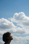Asian woman looking up at clouds